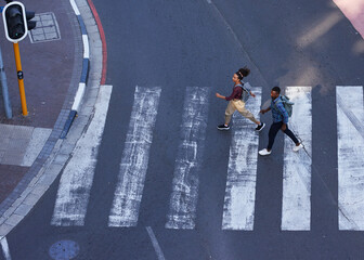 Two young pedestrians cross the road on a crosswalk in the city - obrazy, fototapety, plakaty