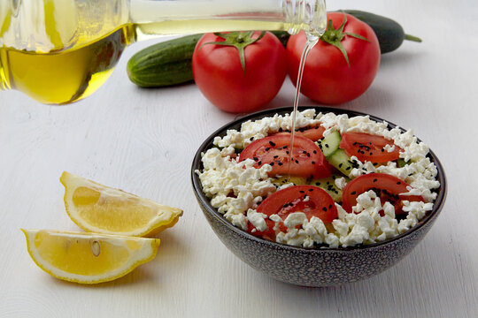 Dressing with olive oil salad of fresh tomatoes, ucumbers, cottage cheese and black cumin