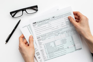 Obraz premium Hands filling US tax form. Culculating and payment of taxes concept