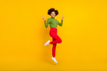 Full length profile side photo of young excited lady show fingers peace v-symbol jump energetic isolated over yellow color background