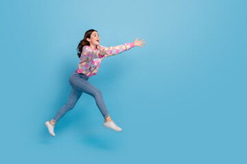 Fototapeta na wymiar Full size profile side photo of young cheerful girl hurry run open hands jump isolated over blue color background
