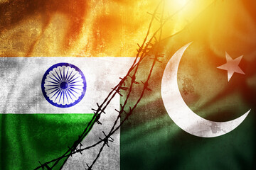 Grunge flags of India and Pakistan divided by barb wire sun haze illustration - obrazy, fototapety, plakaty