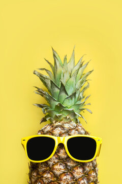 Summertime concept. Pineapple with yellow sunglasses and space for text