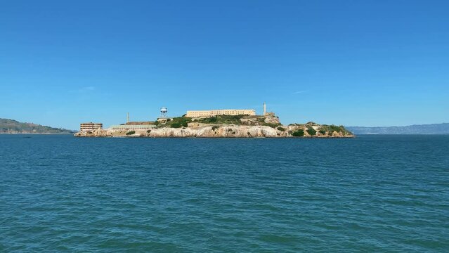 Wide shot pov from sailing boat showing famous Alcatraz Island Prison during sunny day