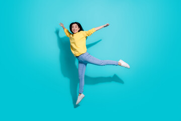 Full length photo of cute charming lady dressed yellow sweater jumping high dancing isolated...