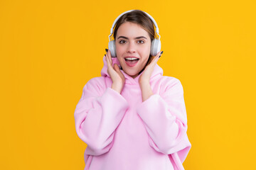 positive girl listen music in headphones on yellow background