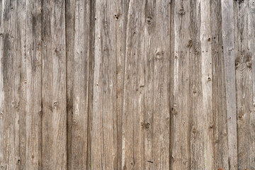 Fototapeta na wymiar Vintage fence of old wooden boards. Texture of an aging wooden surface. Beautiful wooden background.