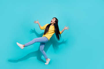 Fototapeta na wymiar Full length photo of pretty impressed lady dressed yellow sweater dancing looking empty space isolated turquoise color background