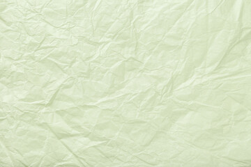 Texture of crumpled pastel green wrapping paper, closeup. Olive abstract background.