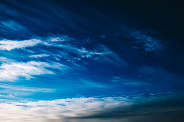Fototapeta na wymiar White spindrift clouds moving fast in dark blue sky. Cloudscape. Nature background. Windy weather forecast. Religion concept. Heaven landscape. Fresh air. Morning inspiration. Art. After storm. Peace
