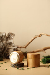 Wooden jars of moisturizer cream with bark of birch, wood branch, green moss. SPA natural organic...