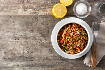 Lentil salad with peppers,onion and carrot in bowl on wooden table. Top view. Copy space