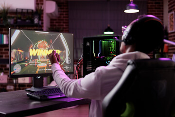 Happy player celebrating video games championship win, streaming online gaming tournament. Cheerful adult winning action rpg gameplay competition on computer, having fun on stream.
