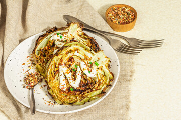 Homemade vegan cabbage steaks with herbs, spices, and sauce. Healthy food ready to eat