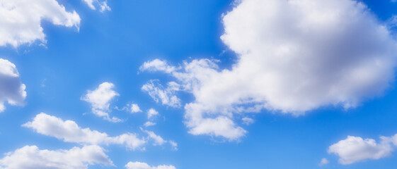Widescreen background of blue sky with white clouds. Soft filter on the image