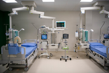Empty Modern technology in intensive care unit room with different equipment and devices, beds and pillows.