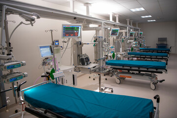 Empty Modern technology in intensive care unit room with different equipment and devices, beds and pillows.
