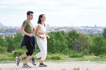 Young sporty couple running outdoors. Two jogger friends.