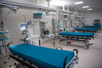 Empty Modern technology in intensive care unit room with different equipment and devices, beds and pillows.