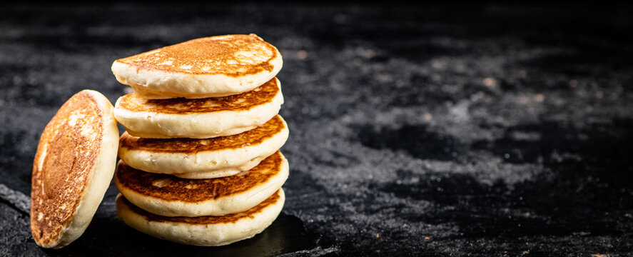Ready made homemade pancakes on a stone board. On a black background. High quality photo
