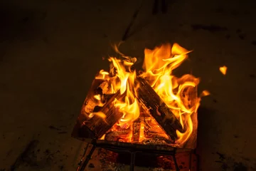 Fotobehang 焚き火台で焚き火をしているところを上からアップで写した炎の写真 © tsuia