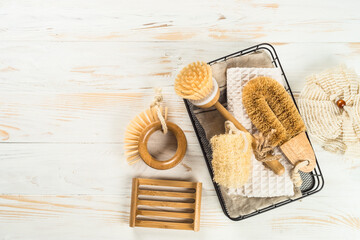Fototapeta na wymiar Zero waste cleaning utensils for kitchen at white wooden table. Natural brushes, soap and towel. Reusable, sustainability, eco-friendly. Flat lay image.