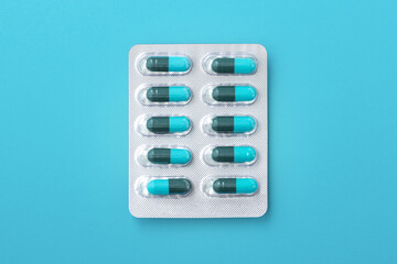 Capsule medicine in pack, antibiotic pills on blue background