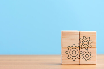 Wooden cubes on blue background with icon of settings seo setting cogwheels configuration gear,...