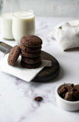 Chocolate chip cookies with milk on a light background. Vertical orientation, top view.