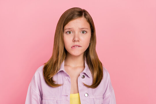 Photo of young girl bite lips worried nervous afraid fail trouble isolated over pink color background