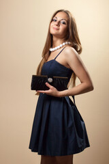 Fototapeta premium Fashionable young woman with a black clutch in her hands