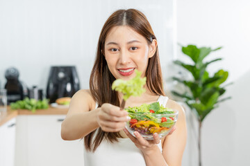 Diet, Dieting asian young woman or girl use fork at lettuce on mix vegetables, green salad bowl, eat  food is low fat good health. Nutritionist female, Weight loss for healthy person.