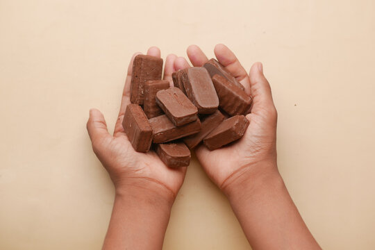 Teenage Boy Holding Many Candy Bar On Table 