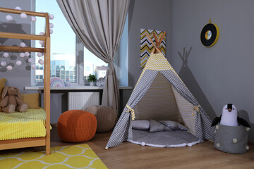 Stylish child room interior with comfortable house bed and play tent