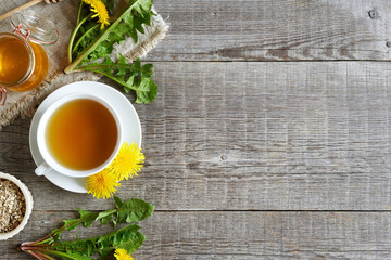 Fototapeta na wymiar Dandelion tea with fresh dandelion flowers and honey on a wooden background with copy space