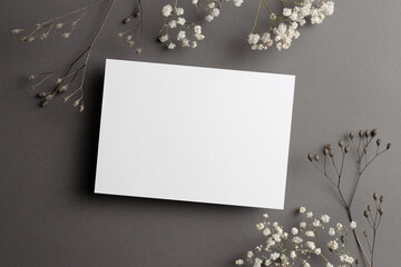 Wedding invitation card mockup with dry flowers twigs on grey