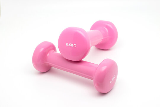 Mancuernas de color rosa sobre fondo blanco para una sesi&oacute;n de deporte, fitness