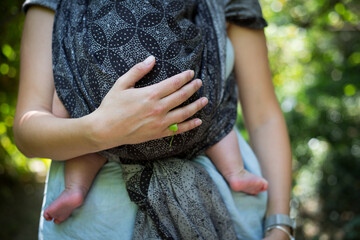 Fototapeta Mama nosi dziecko w chuście, nosidło do noszenia dzieci obraz
