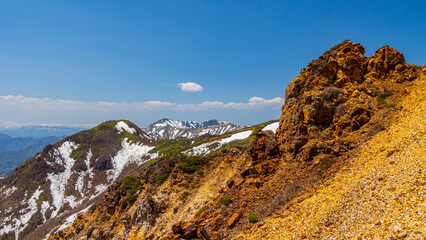 岩と雪渓の残る稜線　那須岳から朝日岳への登山道より