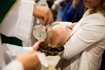 Chrzest Święty, ksiądz polewa głowę dziecka wodą święconą