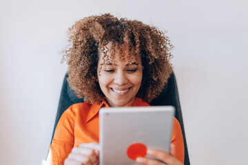 curly hair smiling brazilian woman using pad