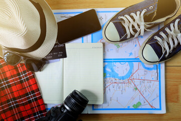 Travel preparation and planning a weekend departure, necessary equipment such as maps, sunglasses, camera, sneakers, hats, credit cards, trip and travel preparation concept.