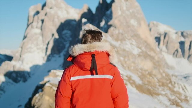 Focus pull Man standing in front of impressive mountain peaks
