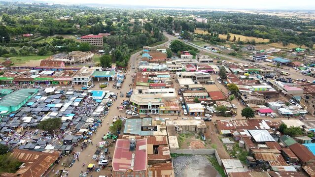 Aerial view of cars and people at a Open Air Market, in Africa - reverse, drone shot