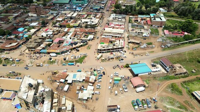 Aerial view of cars and people at a Open Air Market, in Africa - reverse, drone shot
