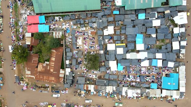 Aerial view of cars and people at a Open Air Market, in Africa - reverse, drone shot