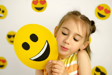 Person looks curiously at the happy emoticon. A diverse emotional state. World emoji day - obrazy, fototapety, plakaty