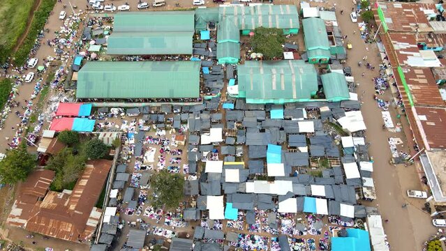 Aerial view of cars and people at a Open Air Market, in Africa - reverse, drone shot