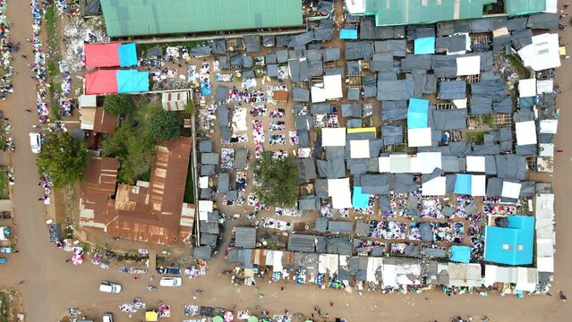 Aerial view of cars and people at a Open Air Market, in Africa - reverse, drone shot