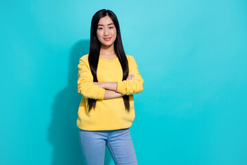 Photo of cute adorable lady dressed yellow sweater arms folded empty space isolated turquoise color background